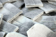 Stack of tea bags with strings tied, arranged in a pattern.