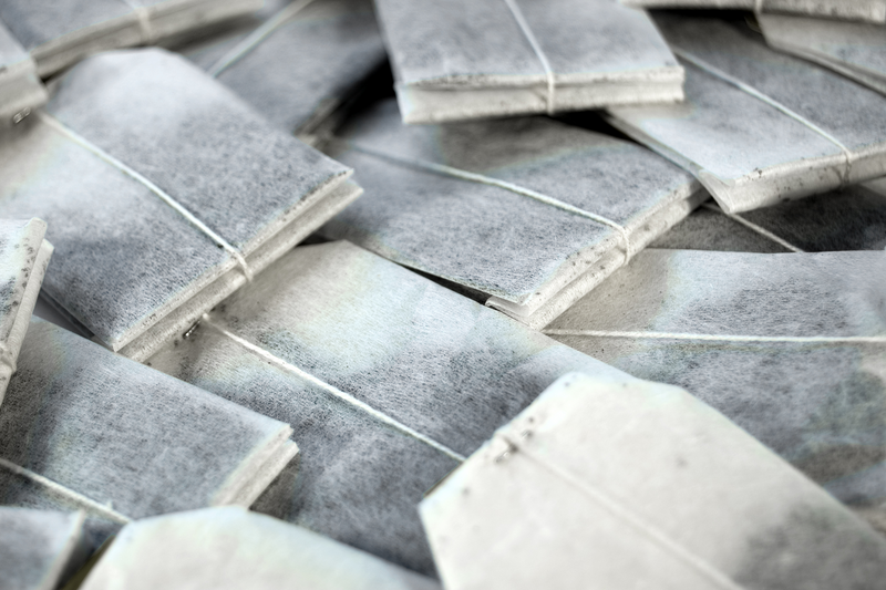 Stack of tea bags with strings tied, arranged in a pattern.